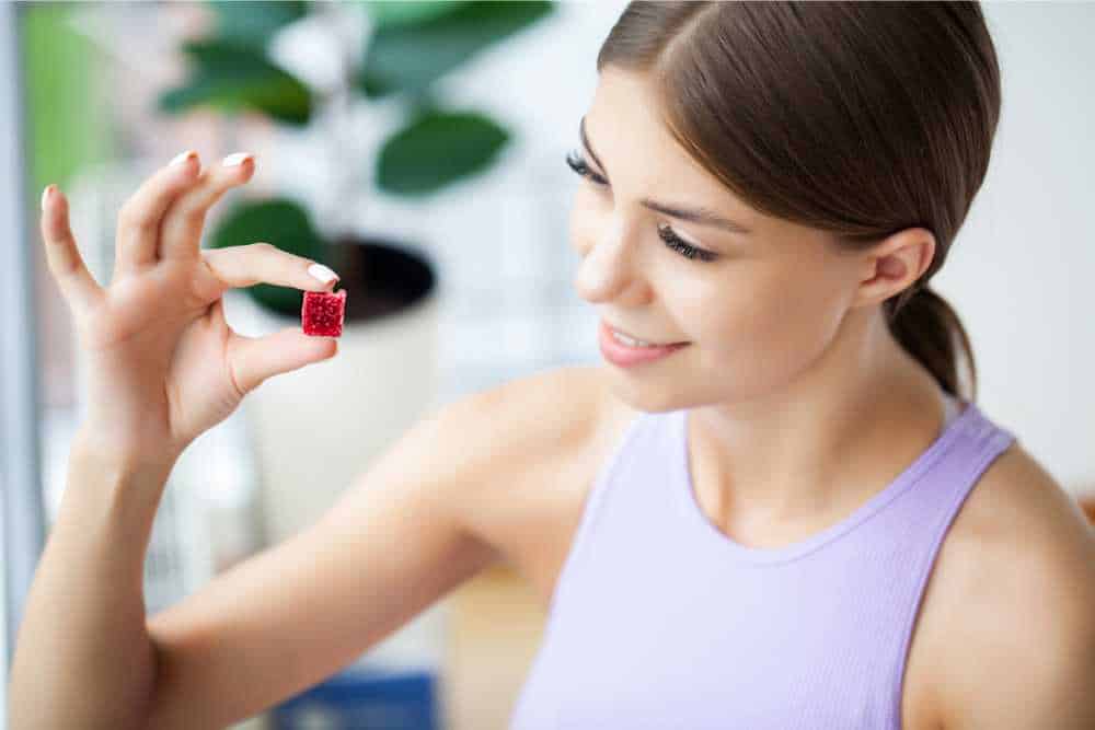 woman holding red gummy cube