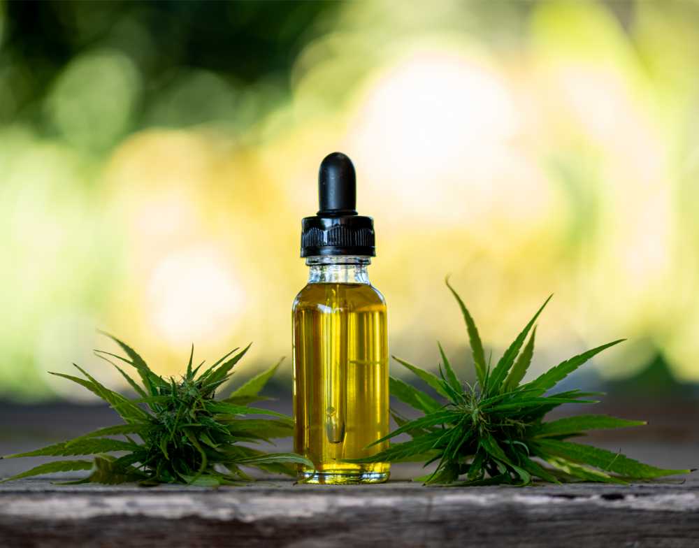 bottle of tincture next to cannabis flower